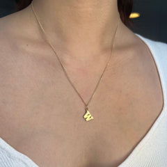 Photo of A woman is wearing Kyle Cavan Gold Washington W Letter Charm ..